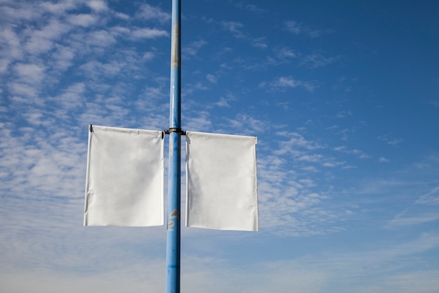 Foto gratuita lámpara blanca en blanco post cartel de bandera contra el cielo azul