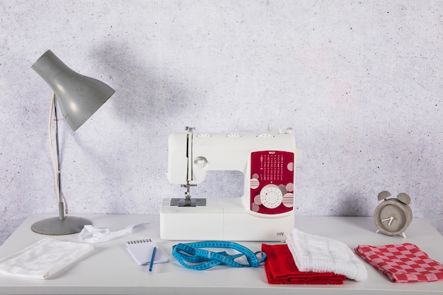 Lámpara cerca de la máquina de coser en la mesa