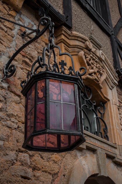 Lámpara exterior de cristal púrpura en edificio antiguo