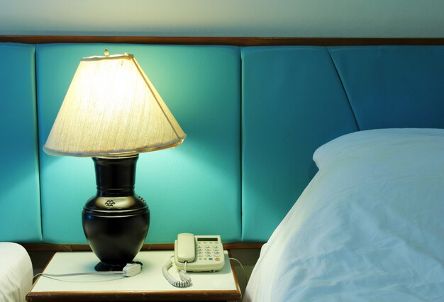 Lámpara de mesa y teléfono en el dormitorio