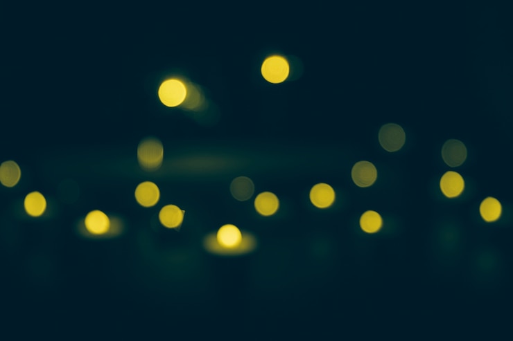 Photo Gratis lampu bokeh kuning yang tidak fokus pada latar belakang gelap