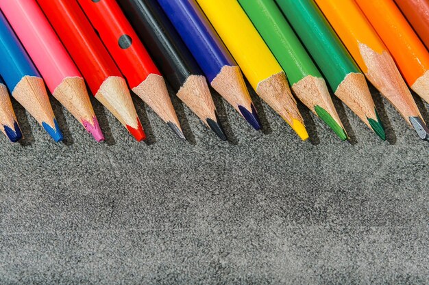 Lápices de colores sobre un fondo gris claro primer plano Colección de útiles escolares plantilla de maqueta de concepto de educación de regreso a la escuela para banner