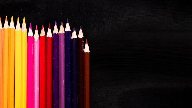 Lápices de colores sobre fondo negro