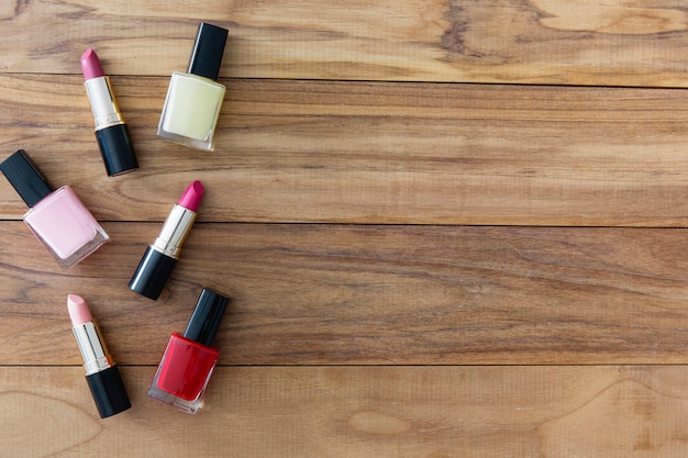 Lápices labiales y esmaltes de uñas en el fondo de madera