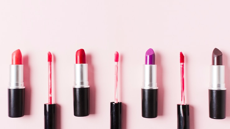 Foto gratuito lápiz labial y pinceles sobre superficie ligera.