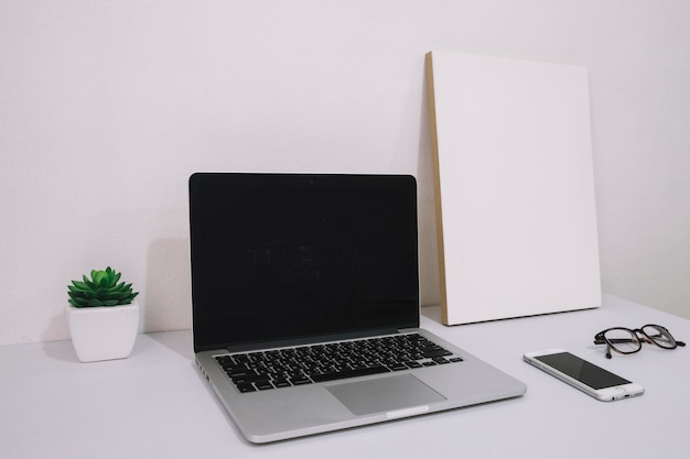 Foto gratuita laptop cerca del cartel en blanco