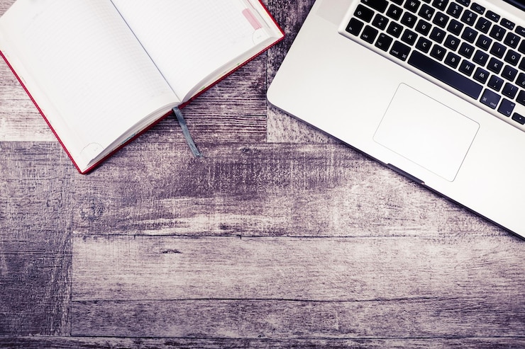 Foto gratuito laptop y un cuaderno para escribir desde arriba sobre un fondo de madera