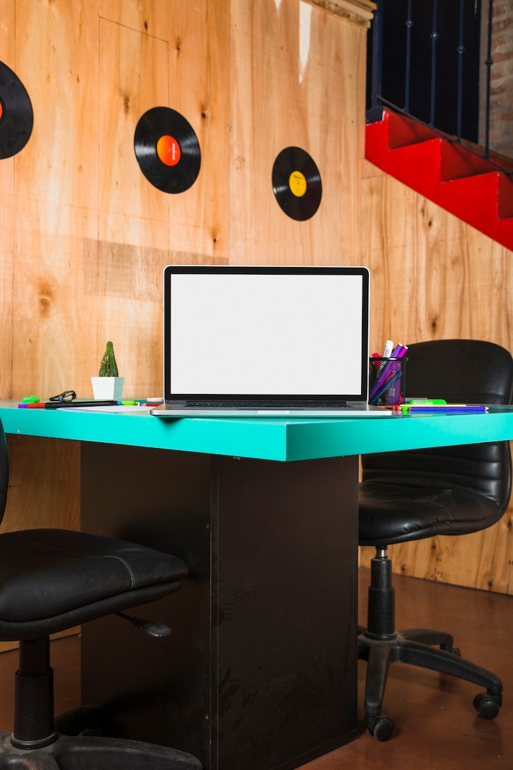 Photo Gratis laptop dengan layar putih kosong di atas meja kayu di kantor