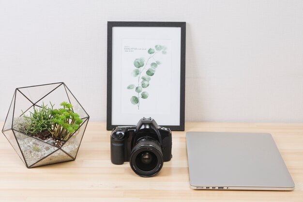 Laptop con foto y camara en mesa de madera