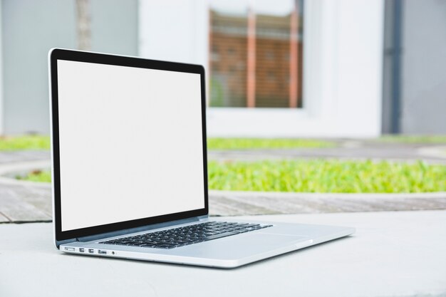 Laptop con pantalla blanca en blanco en pasarela