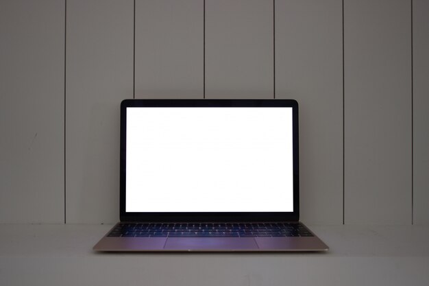 Laptop con pantalla en blanco en madera