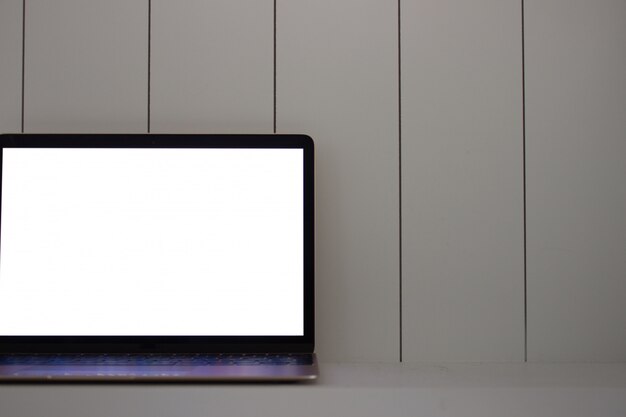 Laptop con pantalla en blanco en madera