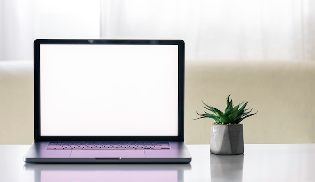 Foto gratuita laptop con una pantalla en blanco en una mesa blanca con una olla de flores