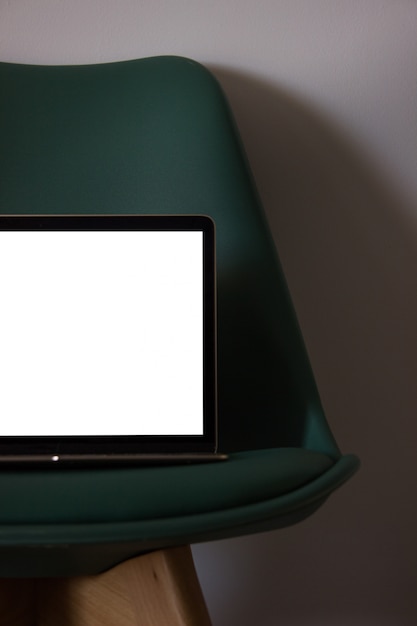 Laptop con pantalla en blanco en silla