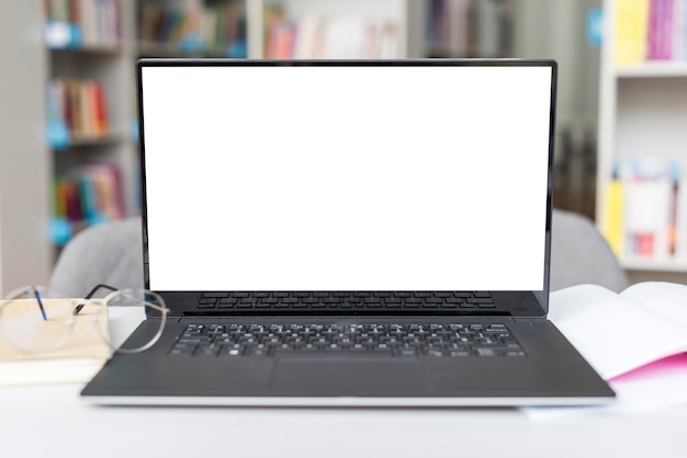 Laptop con pantalla vacía sobre una mesa en la biblioteca