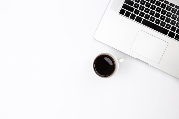 Foto gratuita laptop y una taza de café negro en una vista superior de fondo blanco