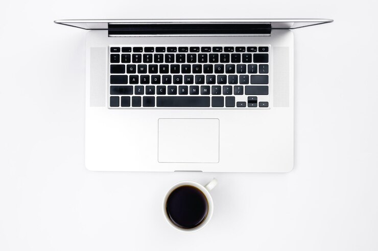Foto gratuito laptop y una taza de café negro en una vista superior de fondo blanco