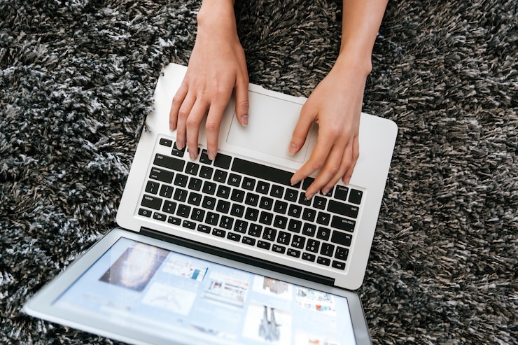 Foto gratuito laptop utilizada por manos de mujer en la alfombra