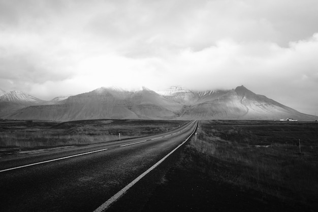 Un largo camino a través del desierto con colinas nubladas en la distancia