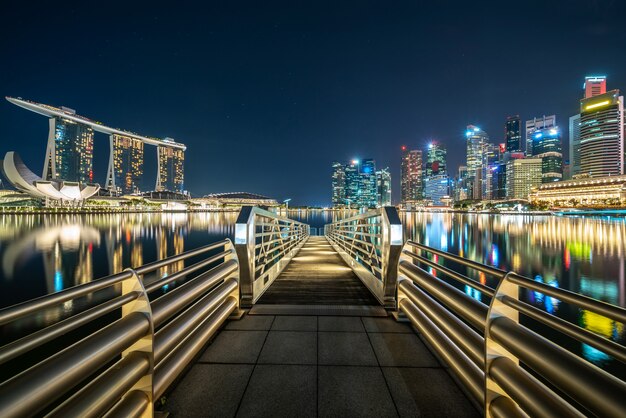 Largo puente entre ciudad iluminada por la noche