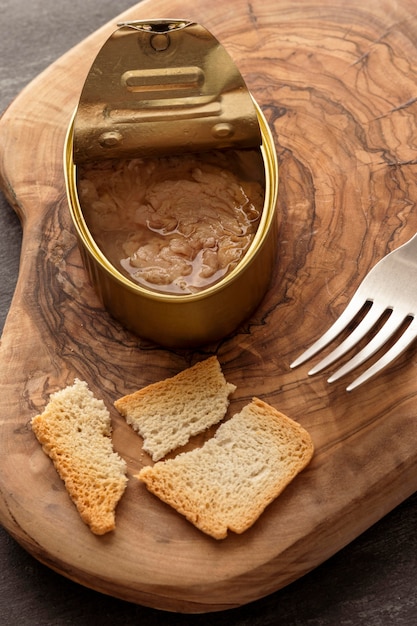 Foto gratuita lata de pescado de ángulo alto con tostadas