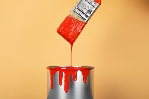 Lata de pintura roja y cepillo