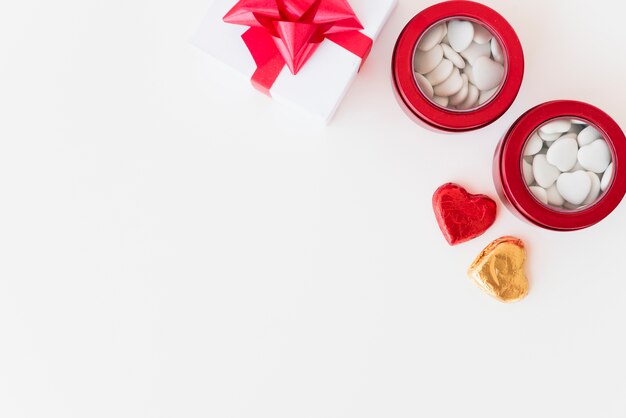 Latas con adorno de corazones y caja de regalo.