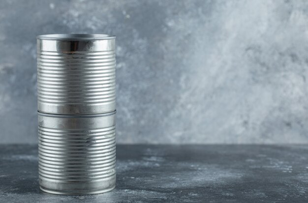 Latas cerradas colocadas sobre mármol.