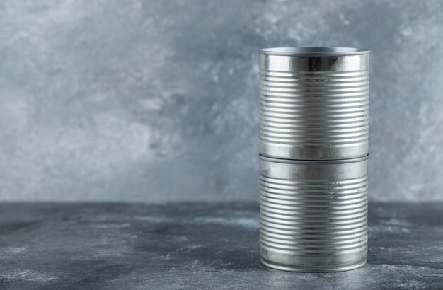 Latas cerradas colocadas sobre mármol.