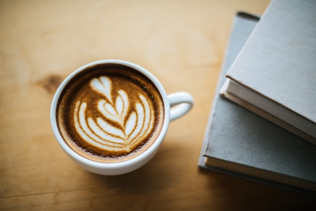 Latte art en taza de café en la mesa de café