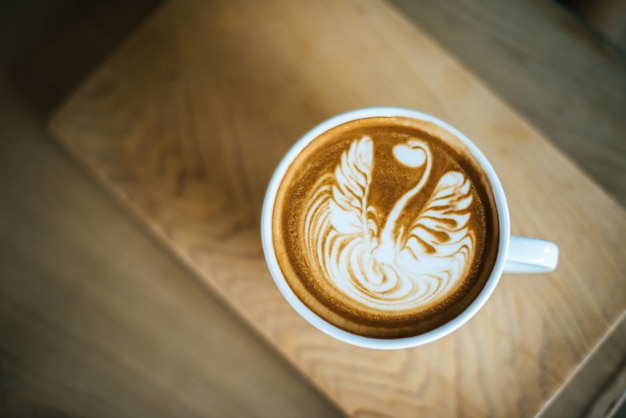 Latte art en taza de café en la mesa de café