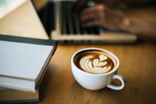 Latte art en taza de café en la mesa de café