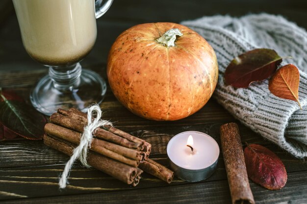 Latte de calabaza picante en una tabla de madera con un suéter