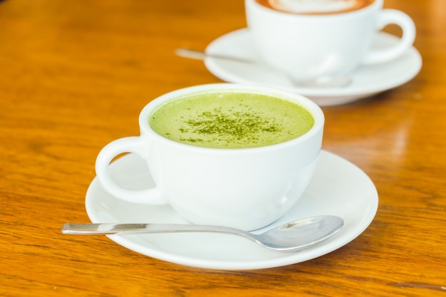 Latte matcha verde caliente en taza blanca