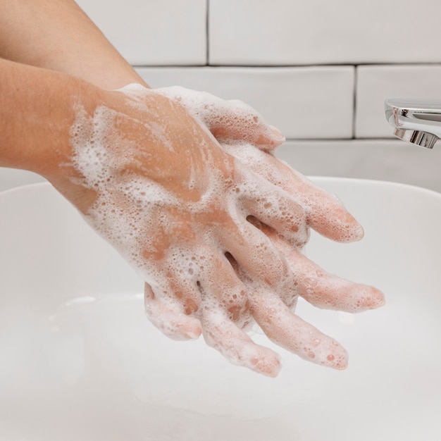 Lavarse las manos frotando con jabón en el fregadero