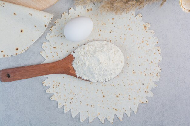 Lavash tradicional, huevo y harina sobre fondo de mármol. Foto de alta calidad