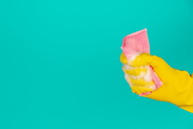 Lavavajillas con guantes amarillos sobre un azul.