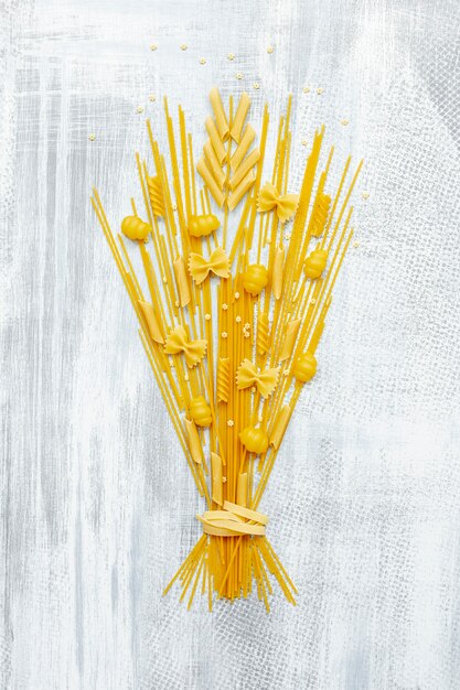 Foto gratuita lay flat de bouquet de pasta sobre fondo de madera