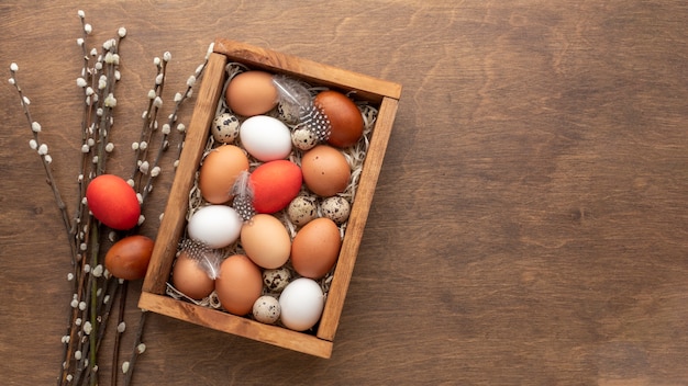 Foto gratuita lay flat de caja con huevos para pascua y espacio de copia