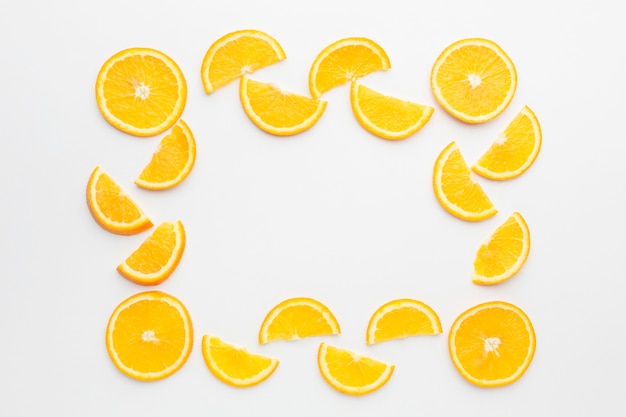 Foto gratuita lay flat del concepto de marco de rodajas de naranja