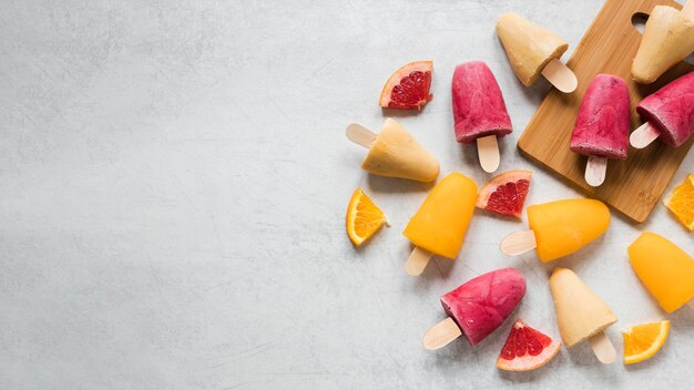 Lay Flat de deliciosas paletas con frutas y espacio de copia