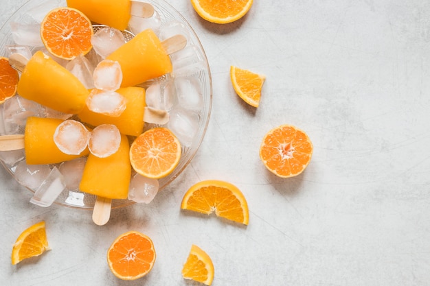 Lay Flat de deliciosas paletas de helado con sabor a naranja con hielo en la placa