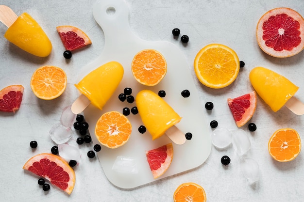 Lay Flat de deliciosas paletas con sabor a pomelo rojo con naranja y arándanos