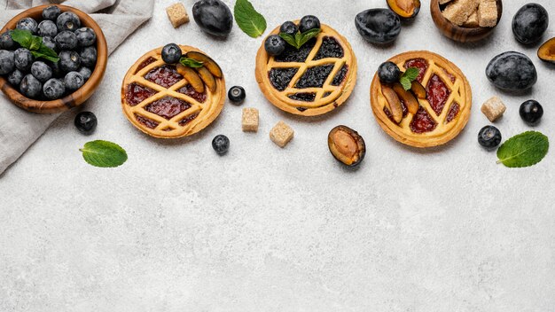 Foto gratuita lay flat de deliciosas tartas de frutas con espacio de copia