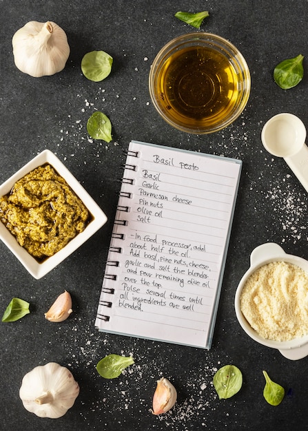 Foto gratuita lay flat de ingredientes alimentarios con cuaderno y aceite