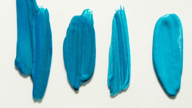 Lay Flat de pinceladas creativas de pintura azul en la superficie