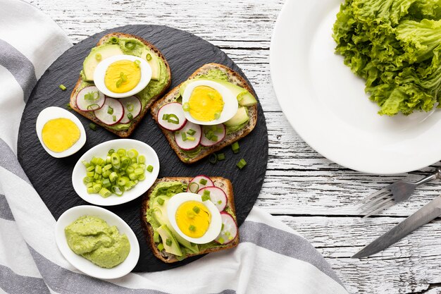 Lay Flat de sándwiches con huevo y aguacate en pizarra