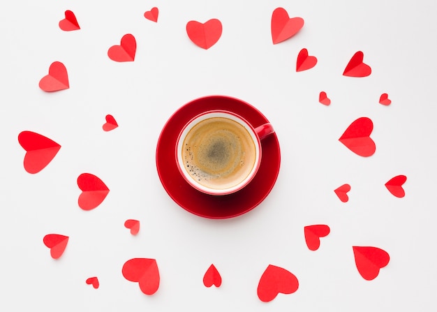 Foto gratuita lay flat de taza de café y papel en forma de corazón para el día de san valentín