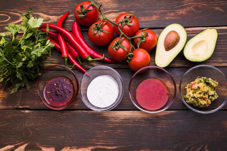 Foto gratuito lay flat de verduras y salsas.