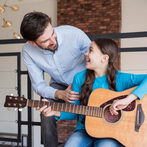 Lección del padre para tocar la guitarra